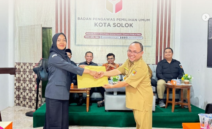 Agustin Melta (kanan) menyerahkan dokumen memori kepada Nurmishbah (kiri) dalam giat Serah Terima Jabatan (Sertijab) Koordinator Sekretariat Bawaslu Kota Solok yang berlangsung di Aula Kantor Bawaslu Kota Solok, Selasa (21/7/2026).