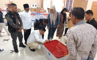 Anggota Bawaslu Kota Solok, Ilham Eka Putra menyaksikan proses pembukaan kotak suara di Gudang Logistik KPU Kota Solok, pada Jum'at, (05/07).