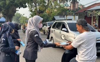 Pembagian Masker kepada pengendara yang melintas di depan Kantor Bawaslu Kota Solok, kepedulian terhadap masyarakat di tengah kondisi kabut asap Senin (14/9/2026).